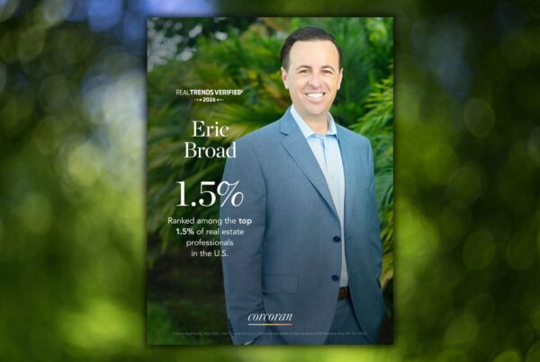 Poster featuring real estate agent Eric Broad in a blue suit, with large 1.5% text and 'Real Trends Verified' at the top, set against green foliage.
